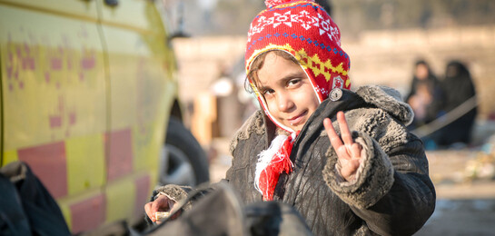 Ein Mädchen aus Syrien freut sich nach der Evakuierung aus Aleppo.