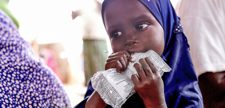 Ein Mädchen in Somalia, Afrika, mit der Notfallnahrung Plumpy Nut Ein Mädchen in Somalia, Afrika, mit der Notfallnahrung Plumpy Nut