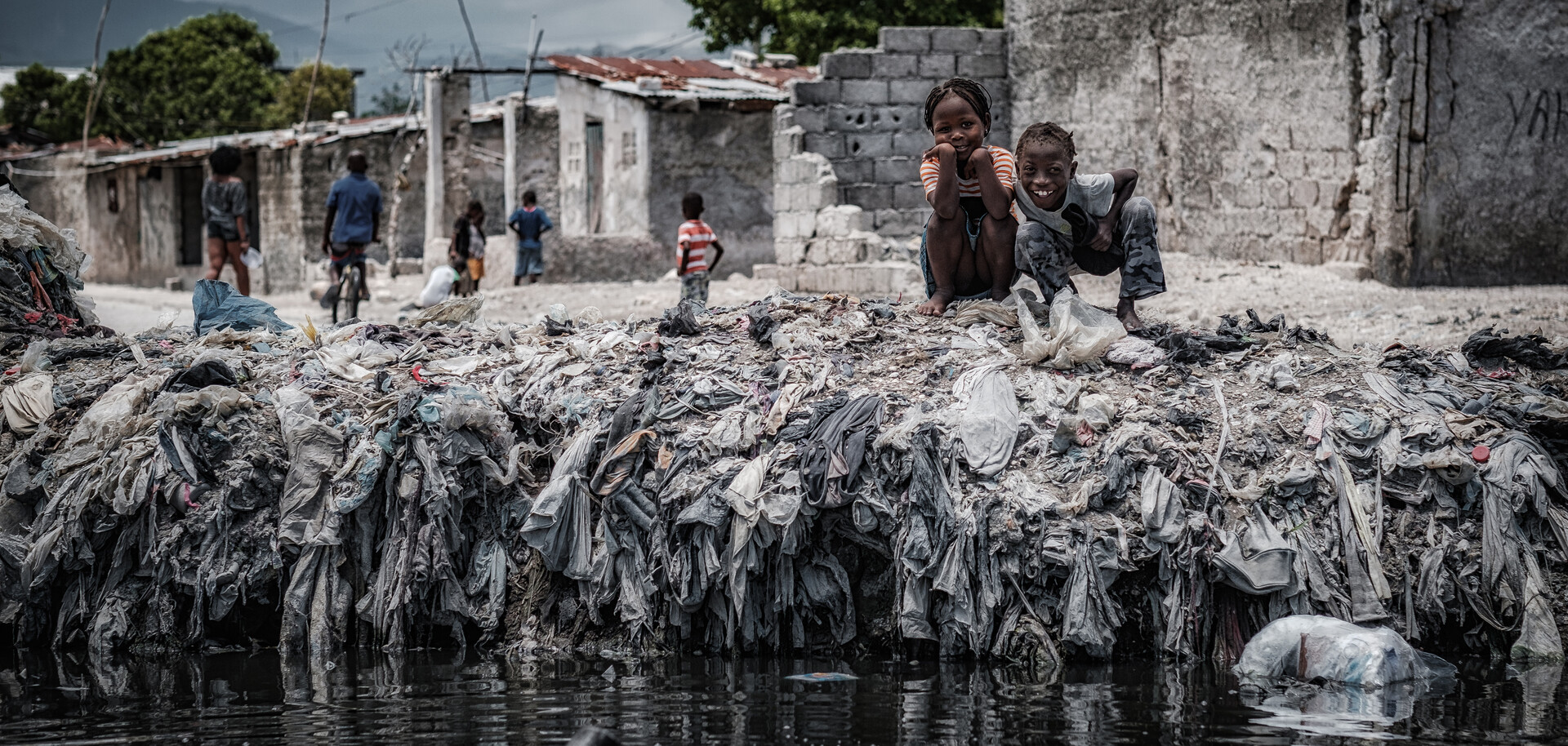 Zwei Kinder spielen in einem Slum in Haiti im Müll Zwei Kinder spielen in einem Slum in Haiti im Müll