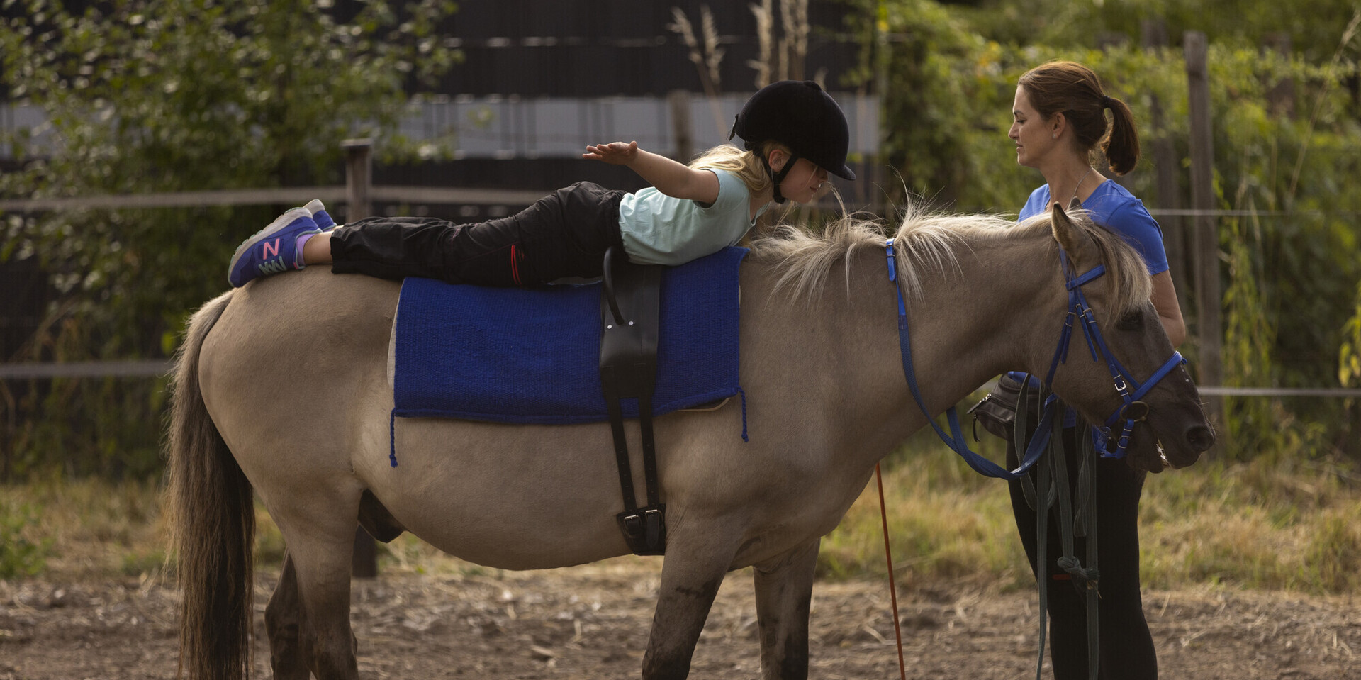 Ein Mädchen übt eine Figur auf Pony Merlin Ein Mädchen übt eine Figur auf Pony Merlin