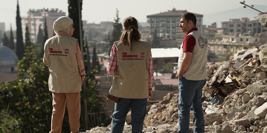 Helfer:innen der Johanniter vor Zerstörung im Erdbebengebiet in Syrien