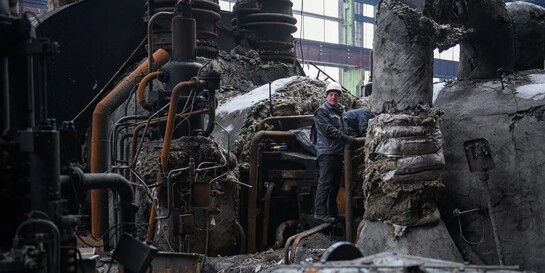 Ein Mann steht inmitten einer zerstörten Anlage zur Energieversorgung