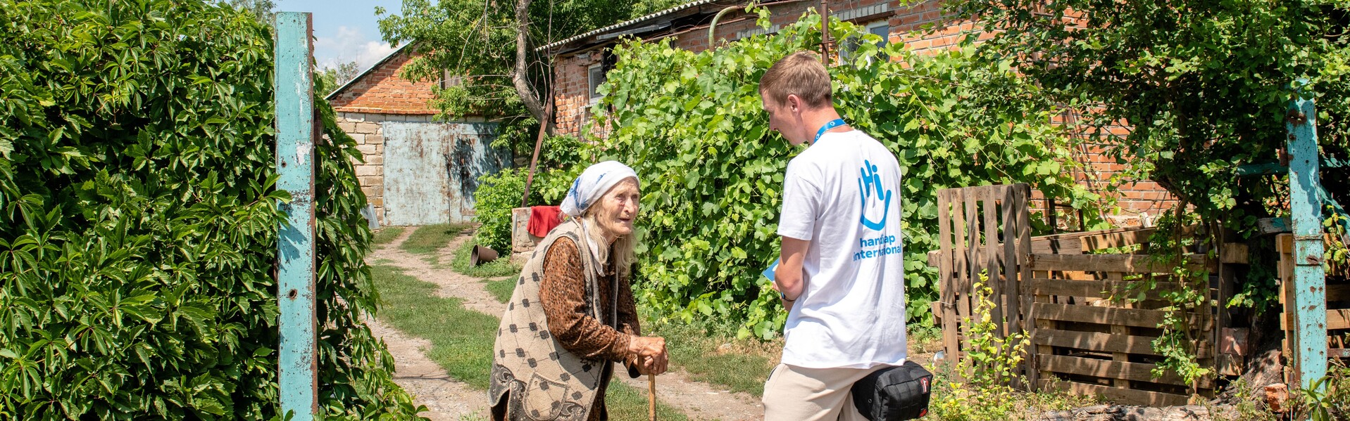 Ein Helfer von Handicap International spricht in der Ukraine mit einer Frau
