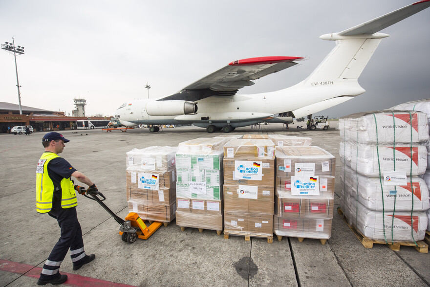 Mitarbeiter entlädt Hilfsgüter am Flughafen.