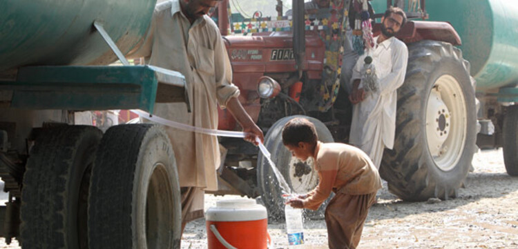 Flut Pakistan: Junge holt Wasser am Wasserwagen Flut Pakistan: Junge holt Wasser am Wasserwagen