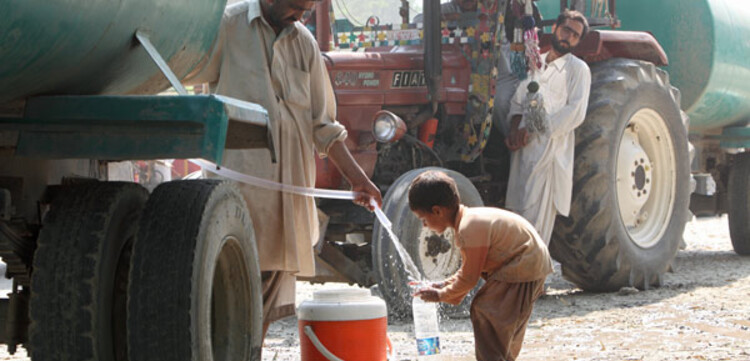 Flut Pakistan: Junge holt Wasser am Wasserwagen