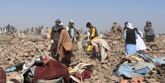 Menschen stehen in Afghanistan nach einem Erdbeben auf Trümmern (Symbolfoto)