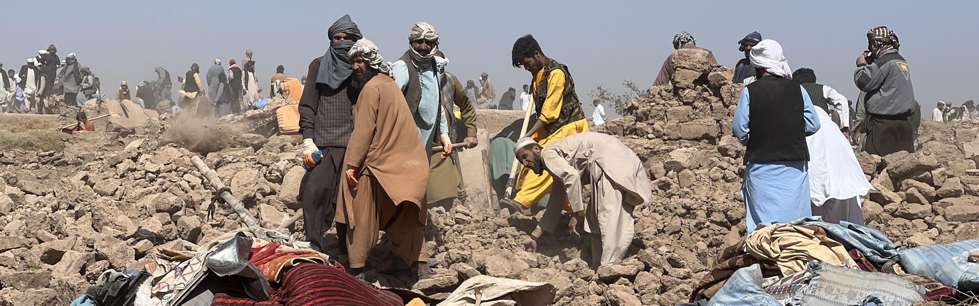 Menschen stehen in Afghanistan nach einem Erdbeben auf Trümmern (Symbolfoto) Menschen stehen in Afghanistan nach einem Erdbeben auf Trümmern (Symbolfoto)
