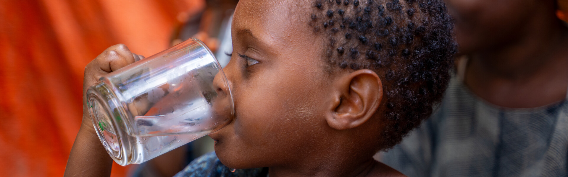 Kleinkind trinkt aus einem Wasserglas Kleinkind trinkt aus einem Wasserglas
