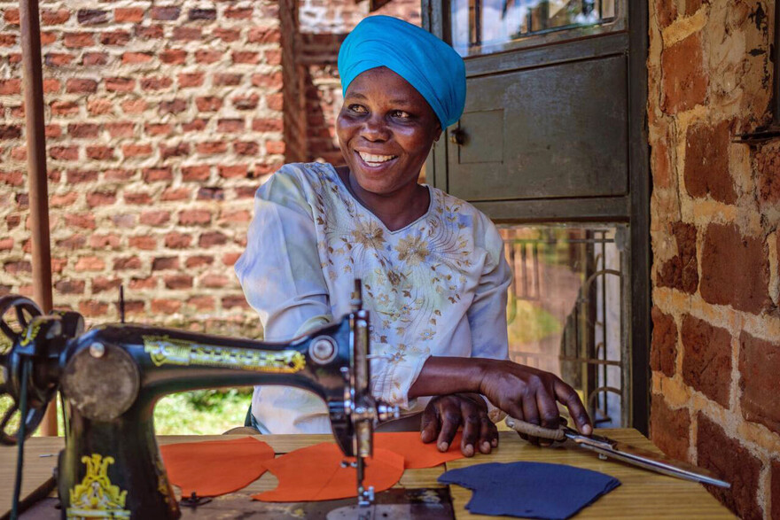 Eine Frau in Uganda sitzt an der Nähmaschine
