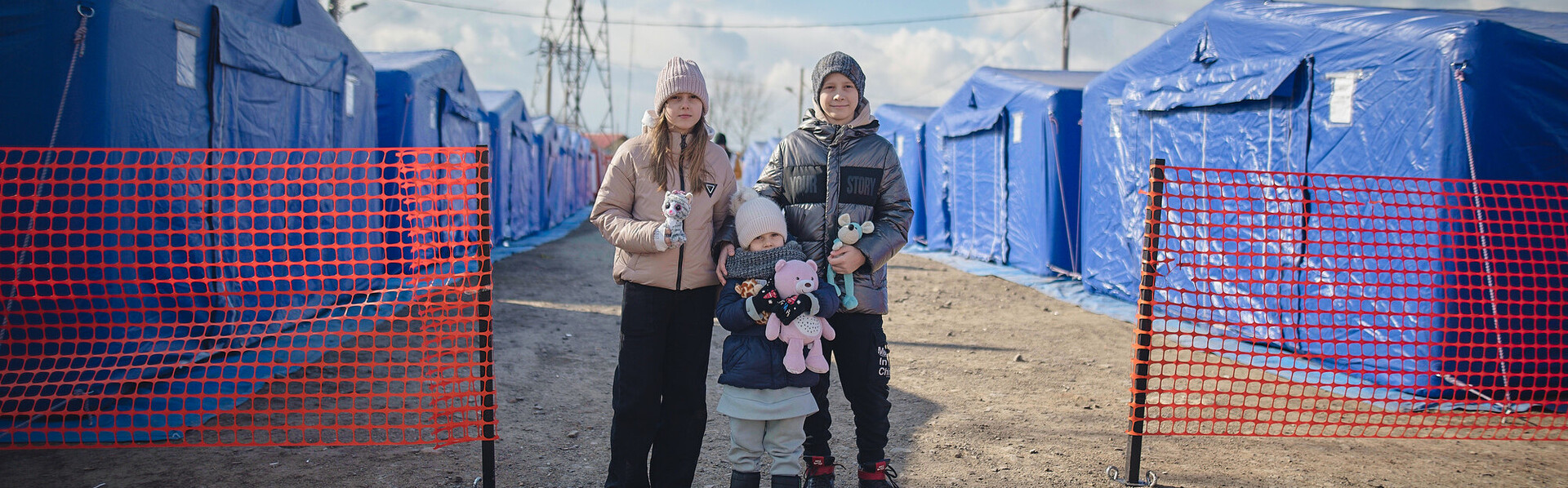 Kinder aus der Ukraine vor Zelten für Geflüchtete in Rumänien