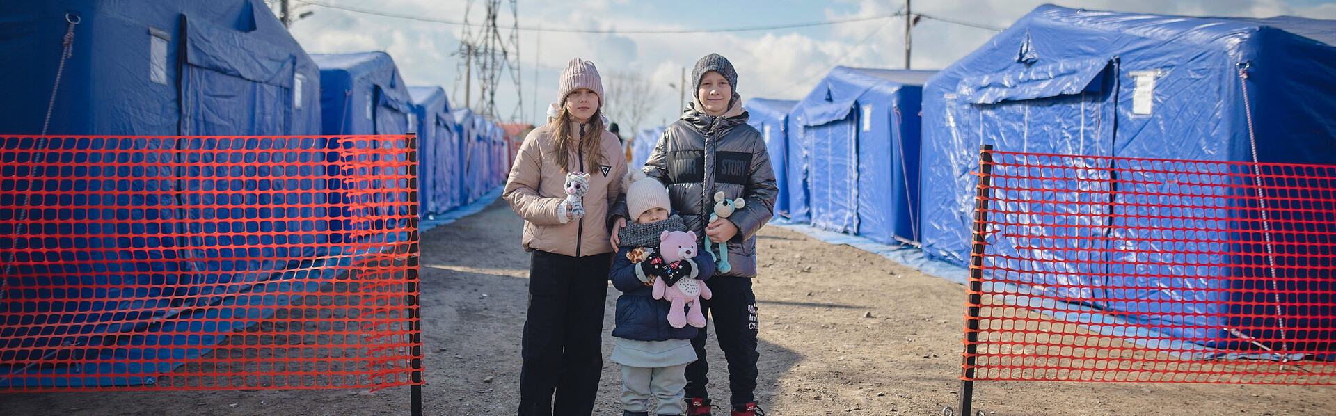 Kinder aus der Ukraine vor Zelten für Geflüchtete in Rumänien