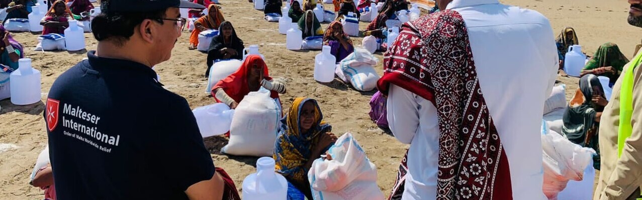Helfer der Organisation Malteser International versorgen die von der Flut betroffenen Menschen mit Wasser und Lebensmittel