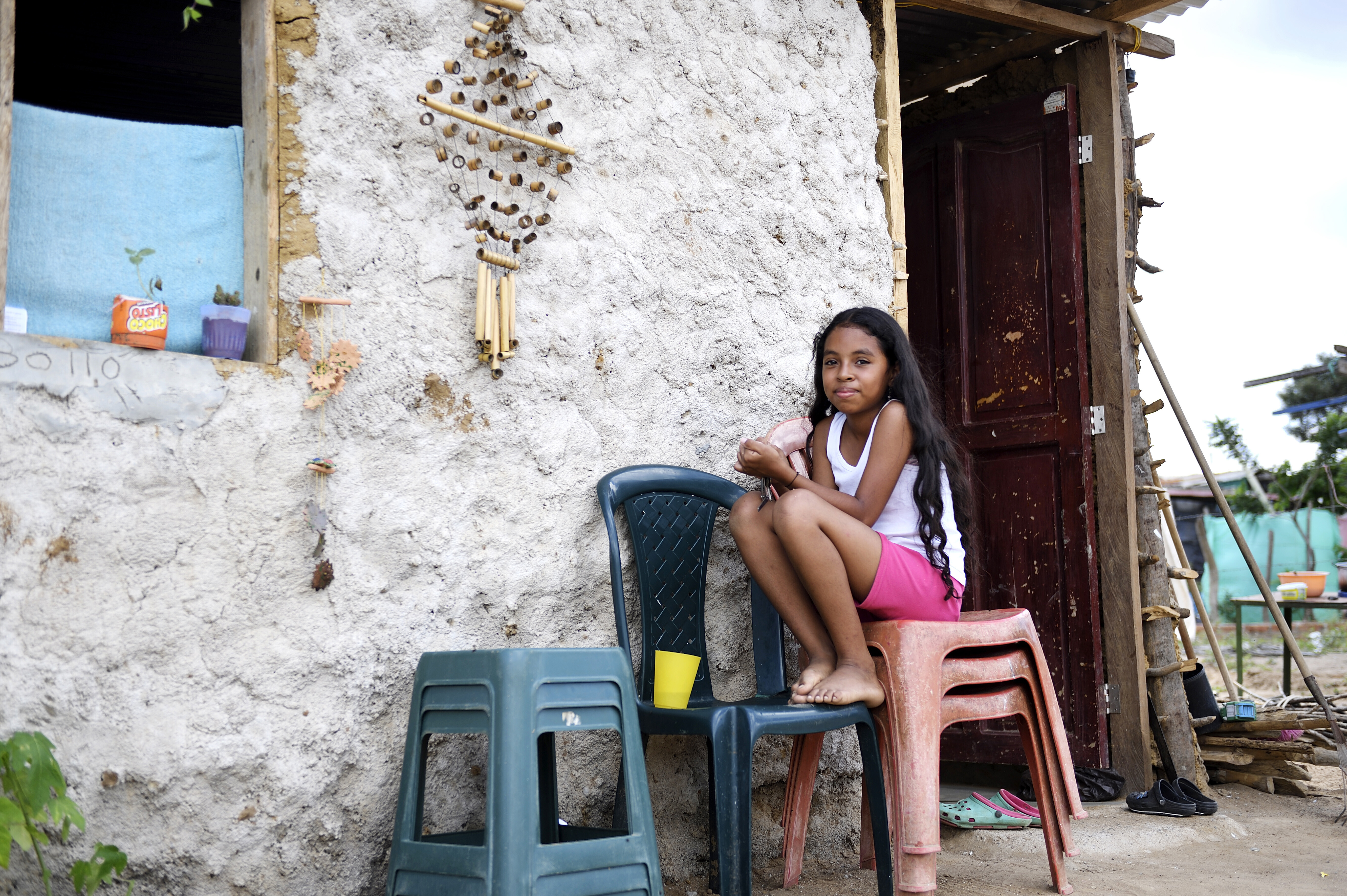 Ein Mädchen aus Venezuela sitzt vor einer Flüchtlingsunterkunft in Kolumbien