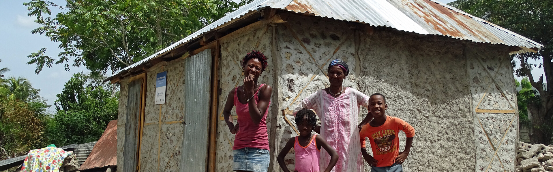 Reselaure Dordi steht mit ihrer Familie in Haiti vor ihrem Haus
