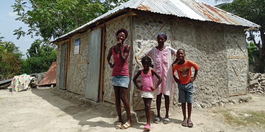 Reselaure Dordi steht mit ihrer Familie in Haiti vor ihrem Haus