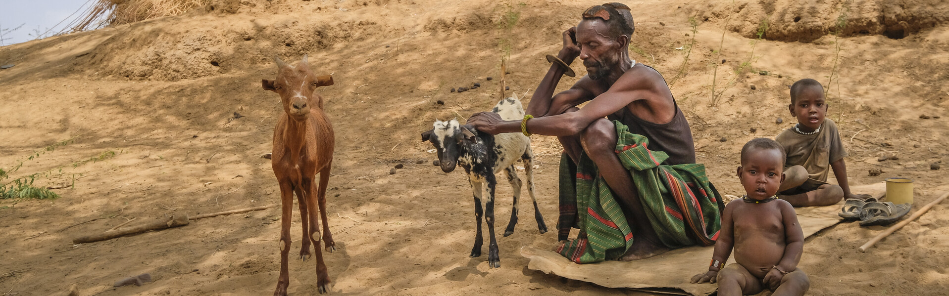 Ein Mann sitzt mit seiner Ziege und seinen Kinder in Kenia. Sie sind Betroffene der Hungerkrise in Afrika