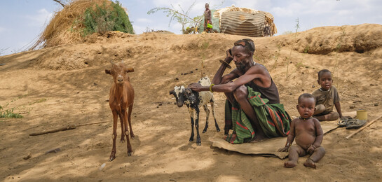 Ein Mann sitzt mit seiner Ziege und seinen Kinder in Kenia. Sie sind Betroffene der Hungerkrise in Afrika