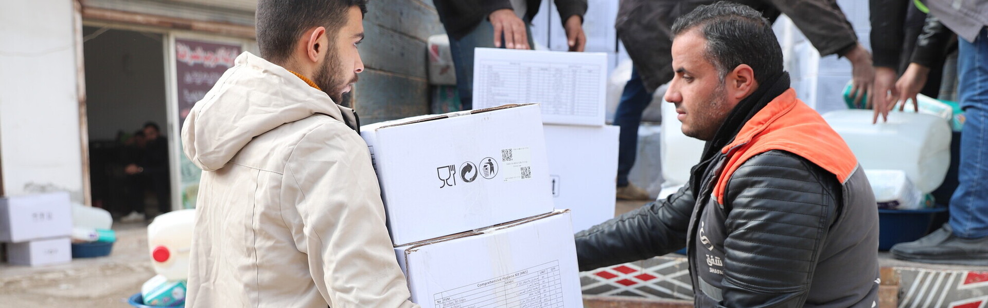 Helfer übergibt Hilfspaket an Mann in Syrien