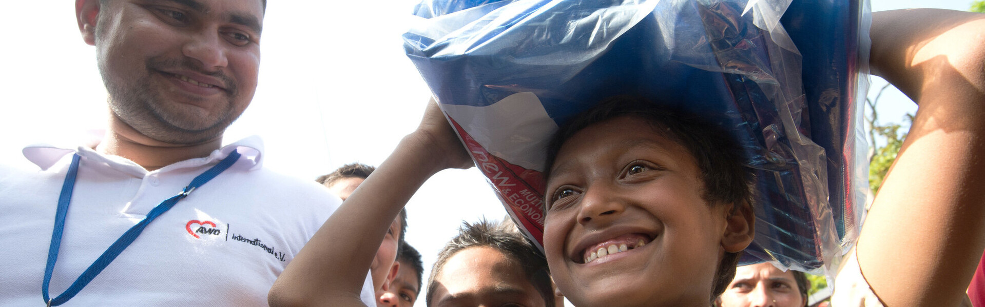 Ein Helfer unseres Bündnisses mit einem Kind in Nepal