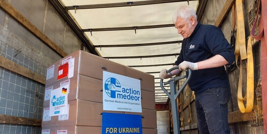 Ein Helfer von action medeor entlädt Hilfsgüter für die Ukraine aus einem LKW