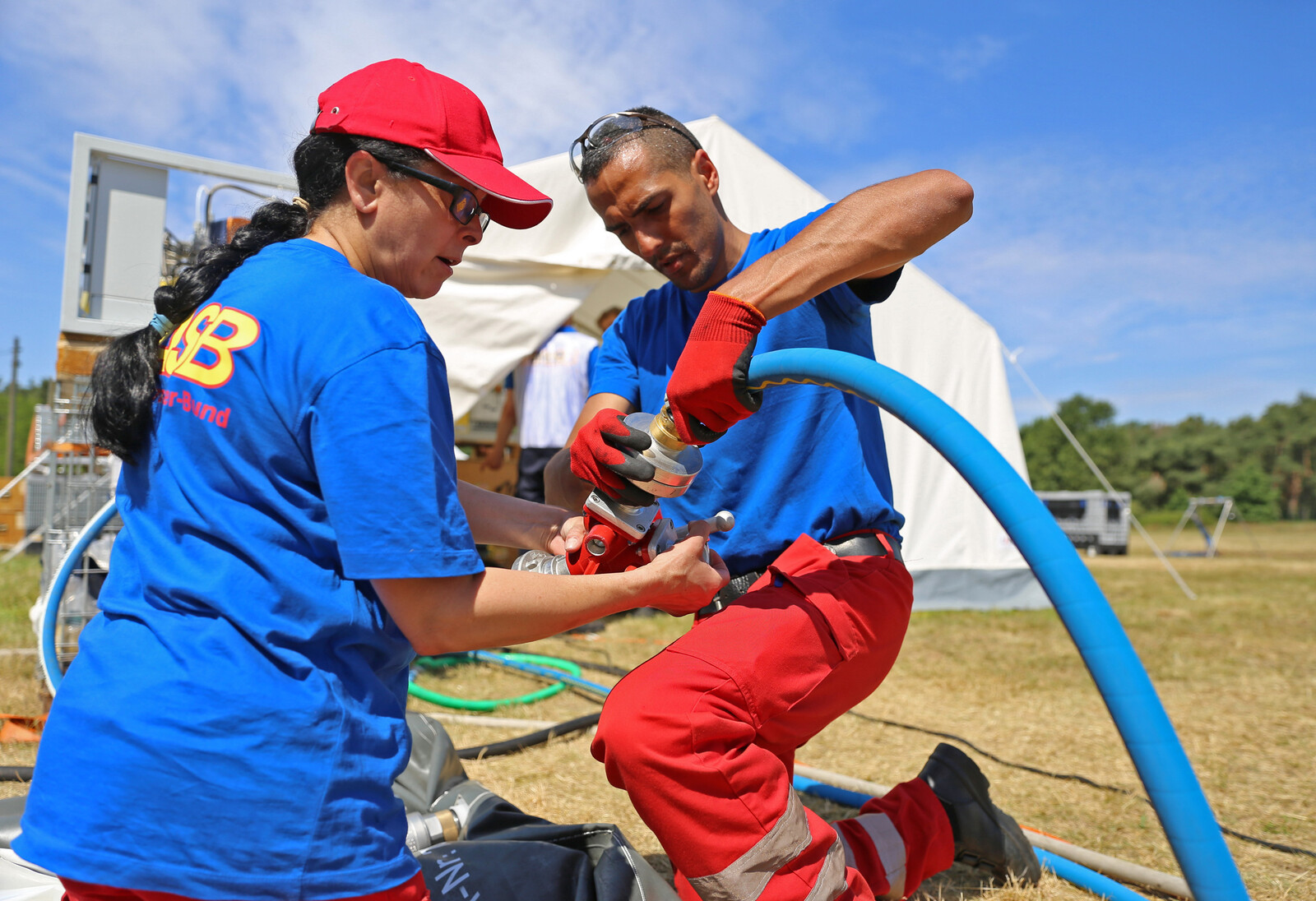 Helfer installieren eine Wasserfiltrationsanlage in einem Flüchtlingscamp 