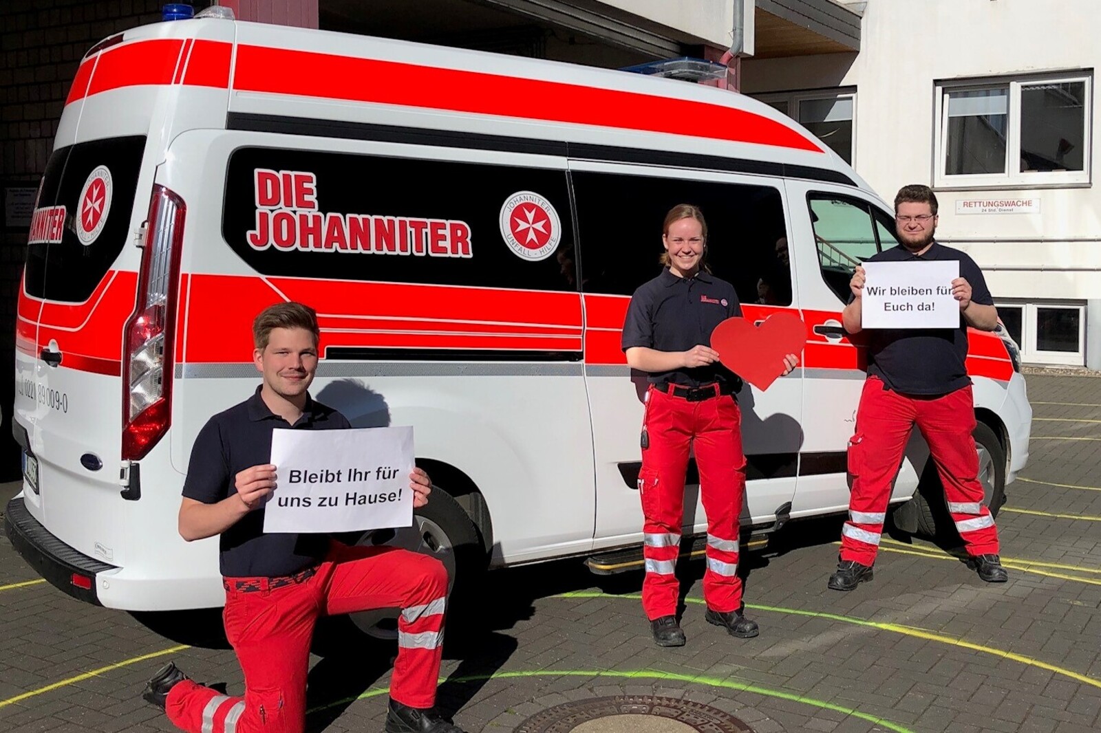 Mitarbeiter der Johanniter-Unfall-Hilfe vor einem Rettungswagen