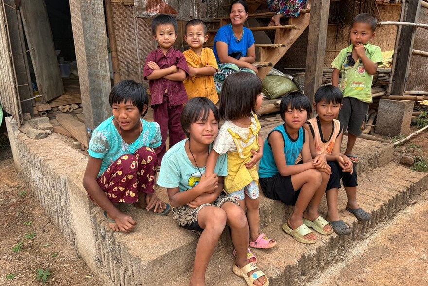 Kinder stehen und sitzen in Myanmar auf Treppenstufen und lächeln