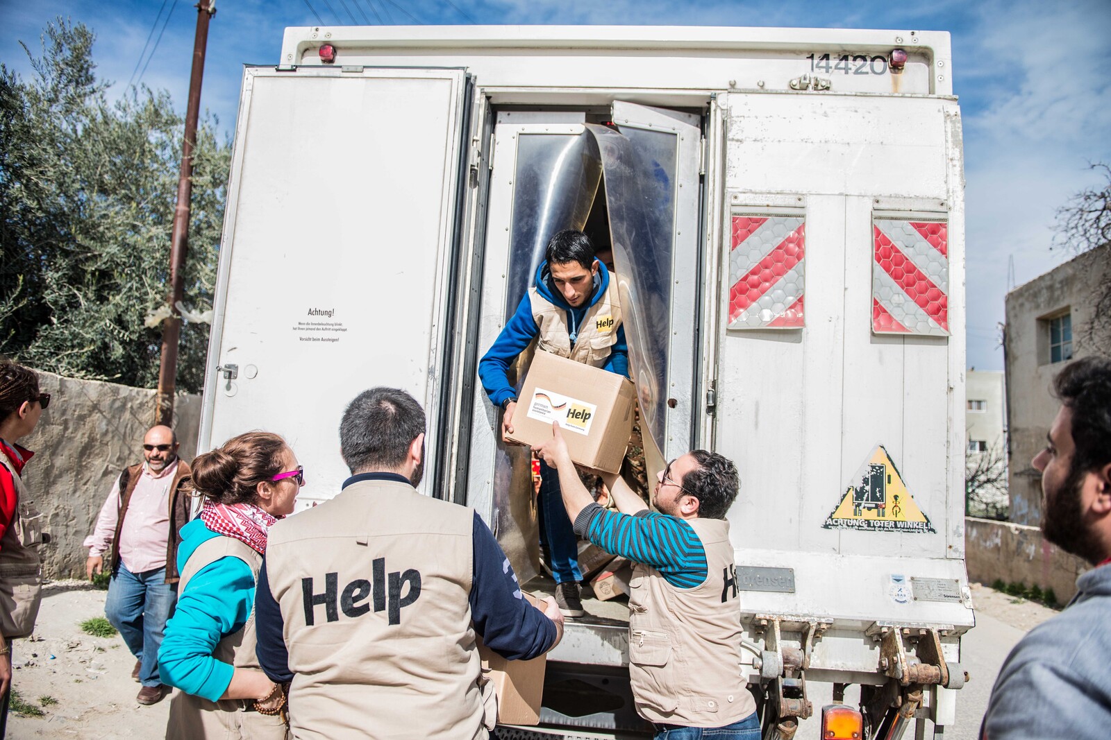 Helfer beim Entladen eines LKWs mit Hilfsgütern für syrische Flüchtlinge
