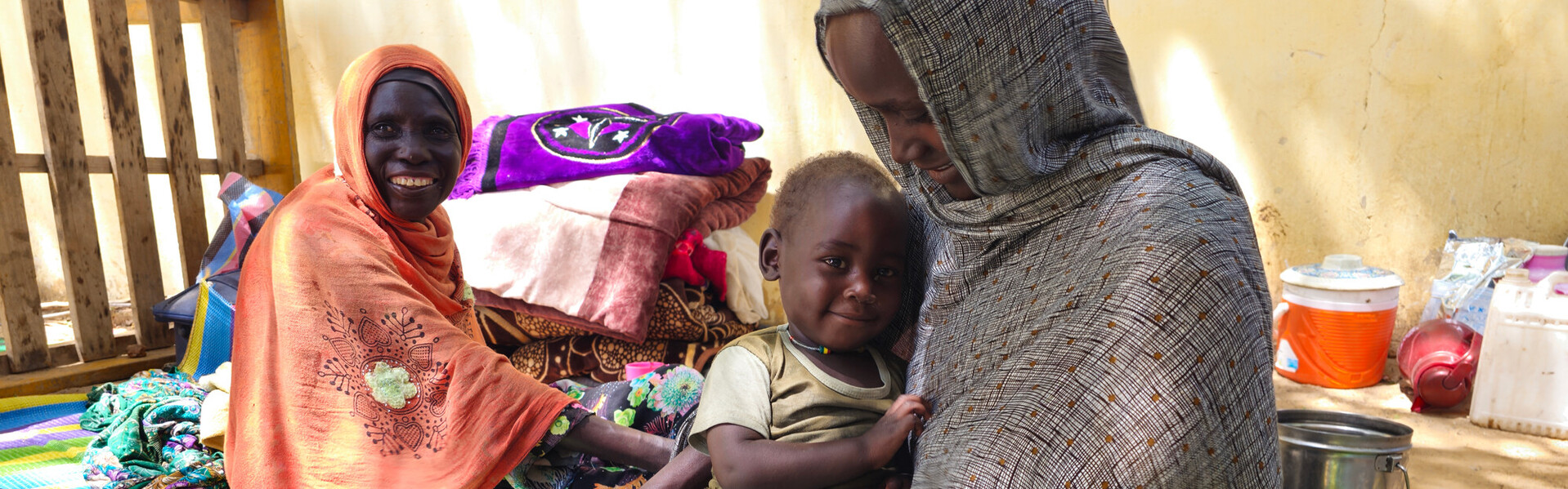 Zwei Frau und ein Baby, die aus dem Sudan geflüchtet sind