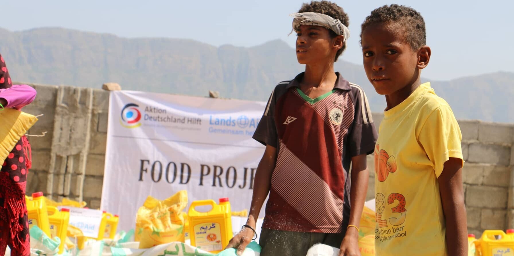 Zwei Jungen mit Lebensmitteln aus einem Hilfsprojekt von LandsAid im Jemen Zwei Jungen mit Lebensmitteln aus einem Hilfsprojekt von LandsAid im Jemen