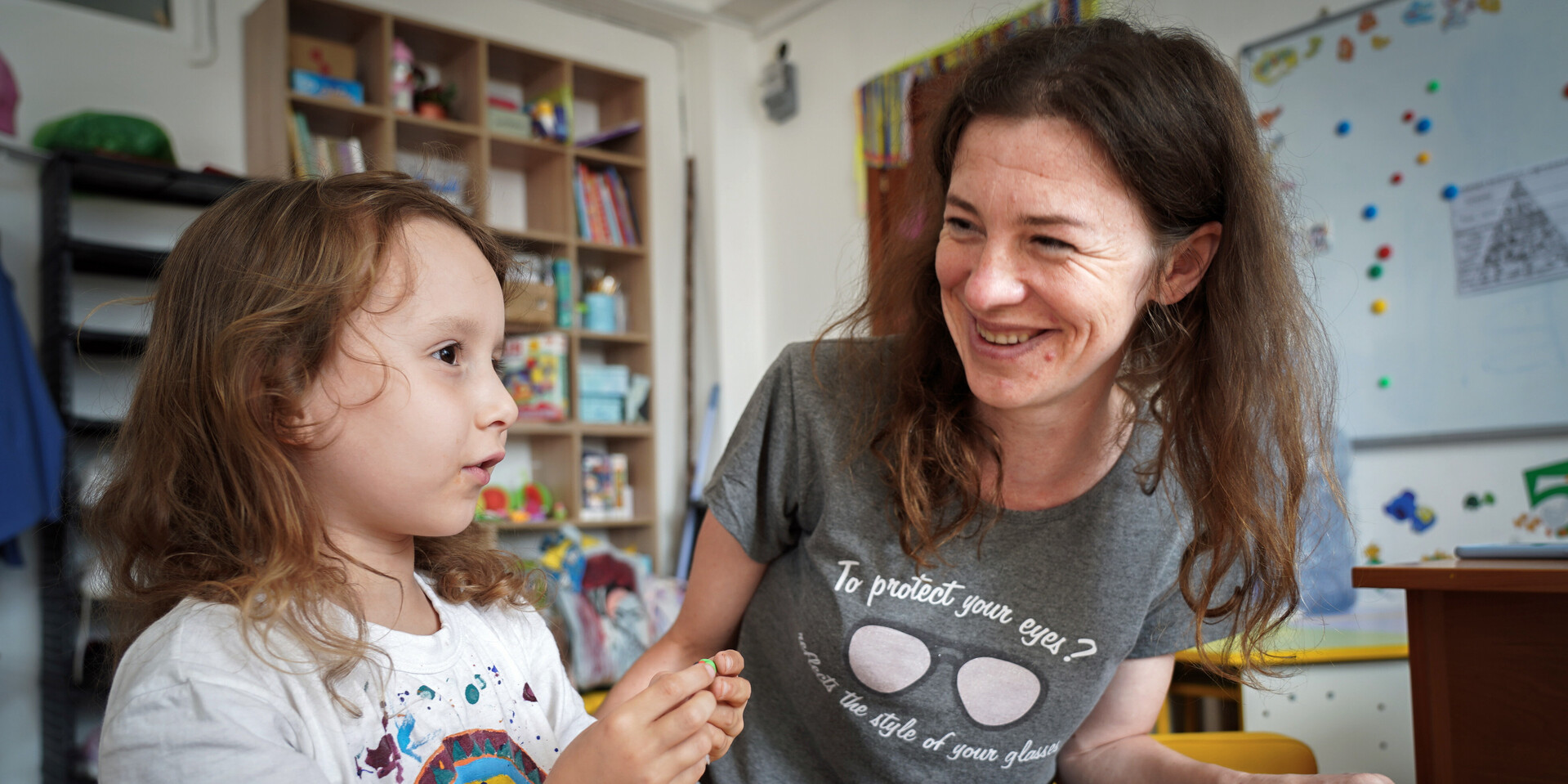 : Freiwillige Helferin im Kinderschuttzentrum mit einem spielenden Kind
