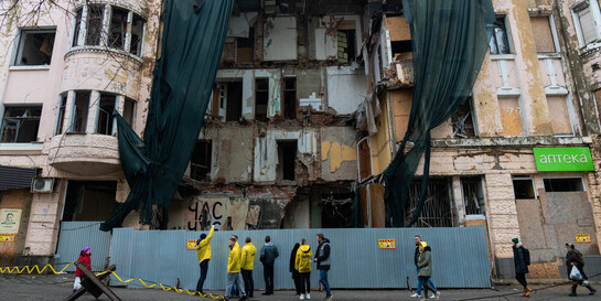 Helfer:innen von Help stehen vor einem zerstörten Haus in der Ukraine