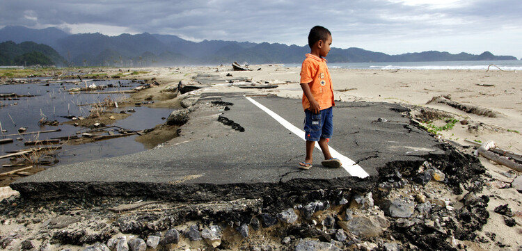 Kind auf einer durch den Tsunami 2004 zerstörten Straße auf Sumatra, Indonesien Kind auf einer durch den Tsunami 2004 zerstörten Straße auf Sumatra, Indonesien