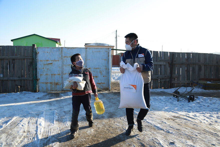Ein Helfer mit einem Kind in der Mongolei Ein Helfer mit einem Kind in der Mongolei