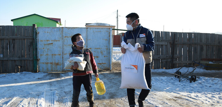 Ein Helfer mit einem Kind in der Mongolei Ein Helfer mit einem Kind in der Mongolei