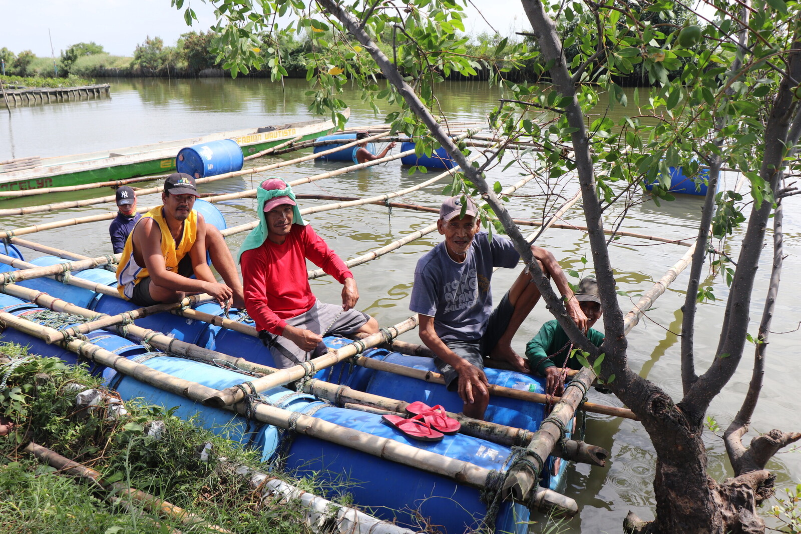 Männer auf einem Boot, das sie zu ihren Häusern im Wasser bringt