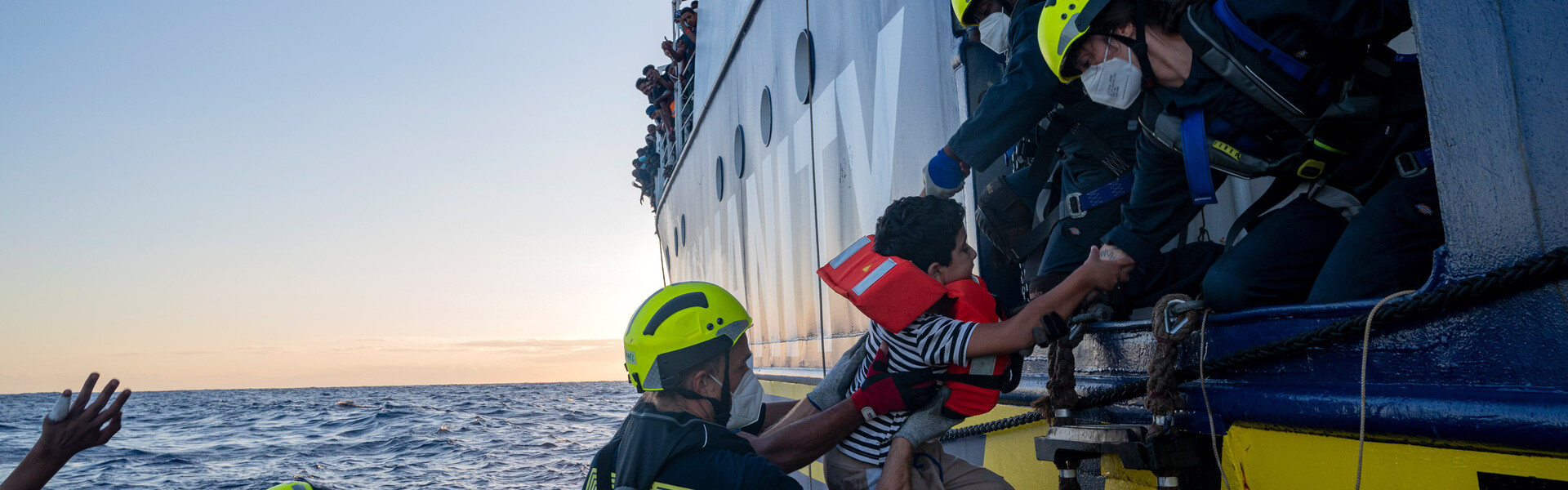 Geflüchtete werden auf Rettungsboot gezogen