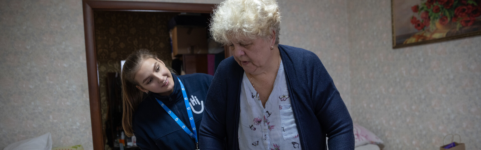 Eine Helferin von Handicap International behandelt eine Frau mit Gehhilfe
