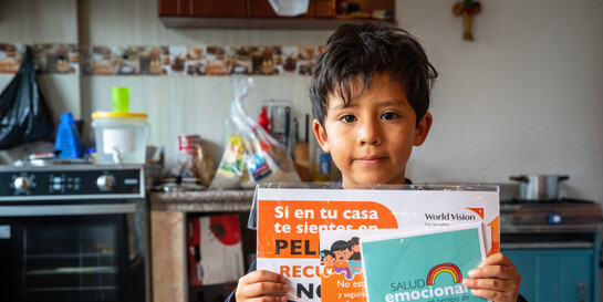 Nicolas aus Ecuador hält Informationsmaterial über das Corona-Virus seinen Händen