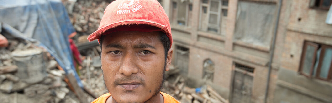 Mann steht in Trümmern in Nepal. Er ist eines der Opfer des Erdbebens in Nepal.