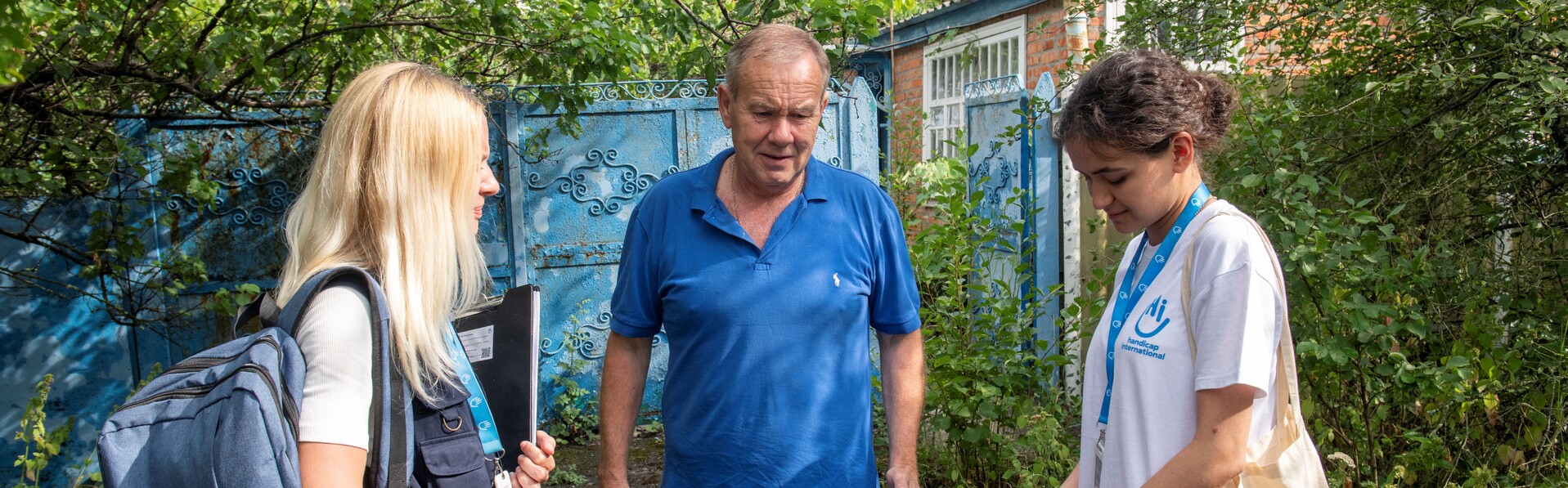 Zwei Helferinnen sprechen mit einem Mann 