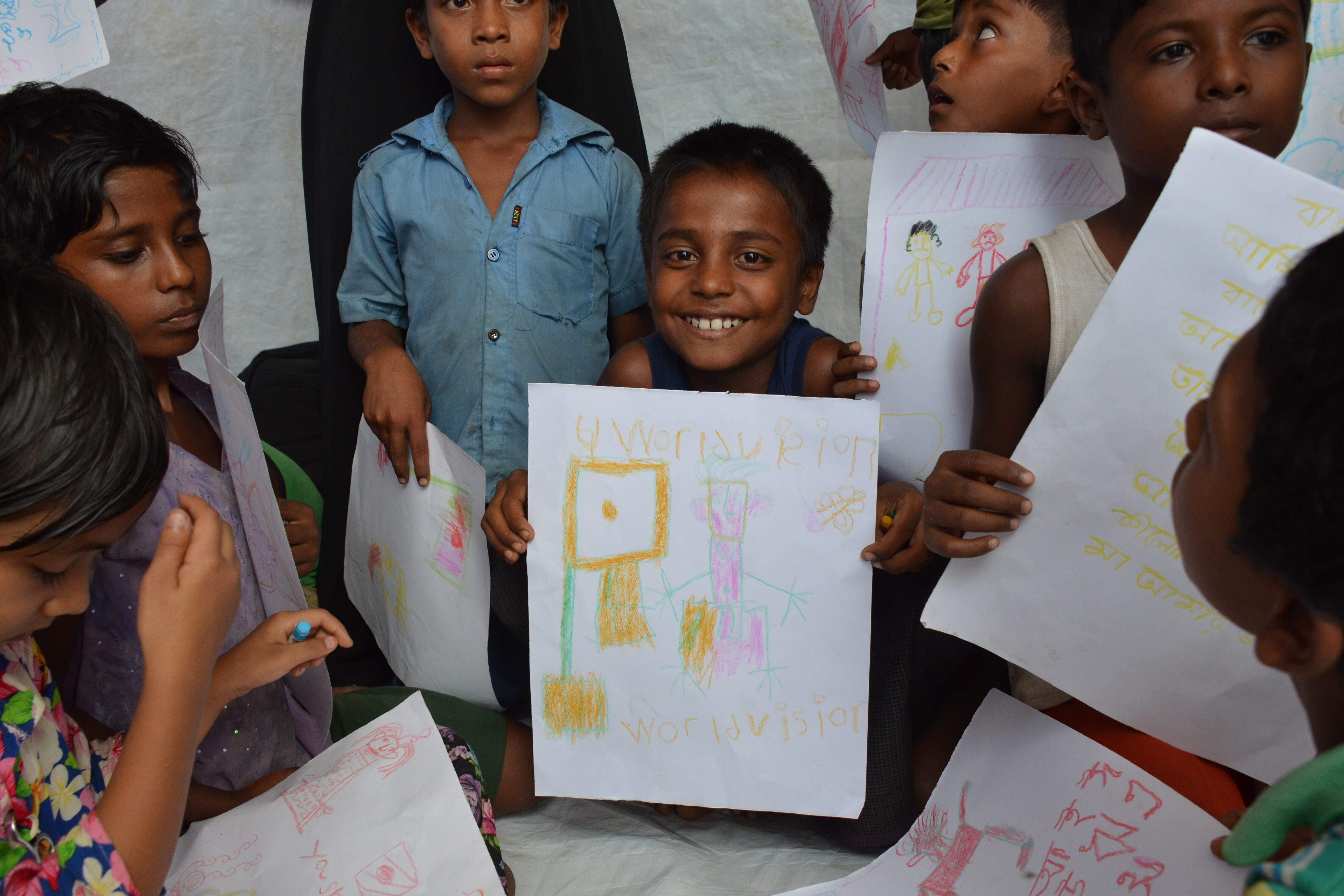 Kinder mit ihren gemalten Bildern in einem Flüchtlingscamp in Bangladesch Kinder mit ihren gemalten Bildern in einem Flüchtlingscamp in Bangladesch