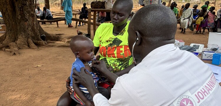 Helfer im Südsudan untersucht Kind Helfer im Südsudan untersucht Kind