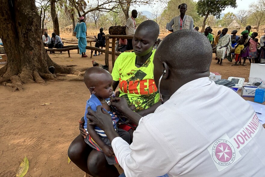 Helfer im Südsudan untersucht Kind Helfer im Südsudan untersucht Kind