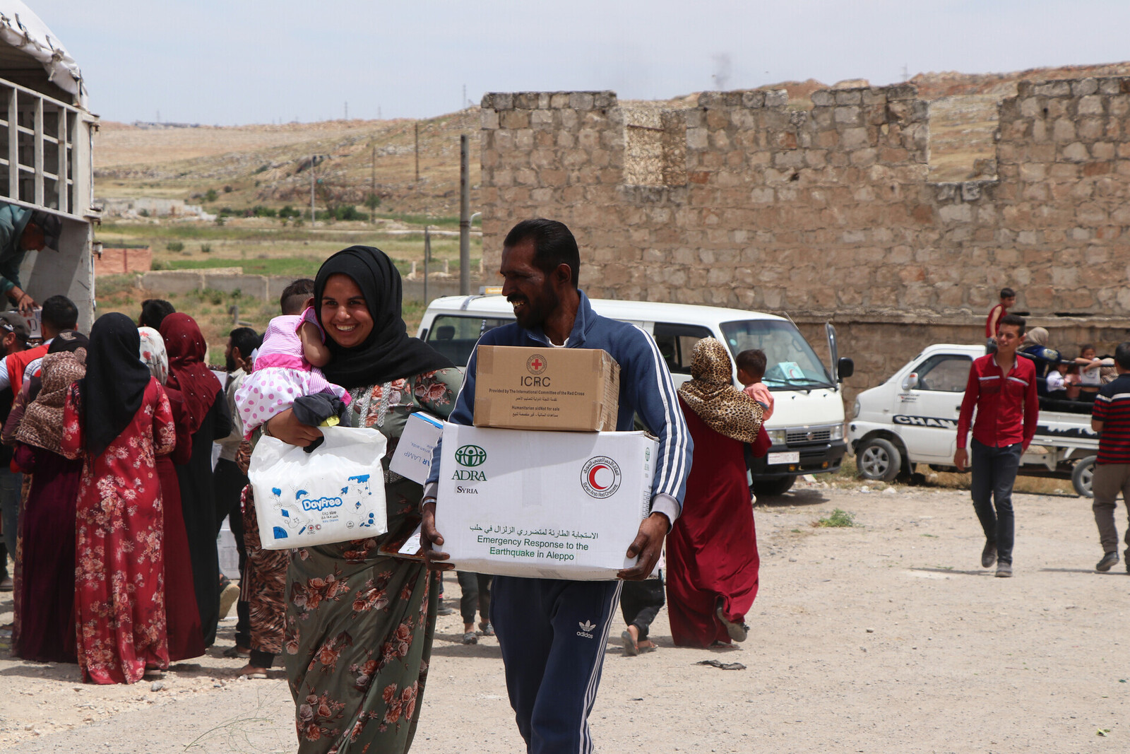 Ein Mann und eine Frau mit Hilfspaketen in Syrien
