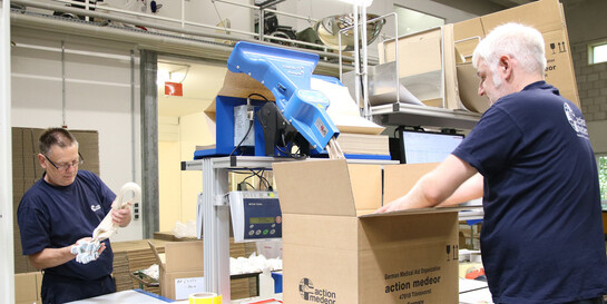 Mitarbeiter von action medeor verpacken im Lager Hilfsgüter (Symbolbild)