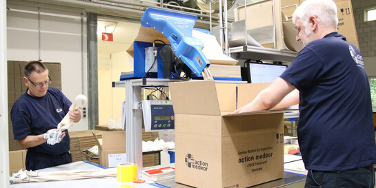 Mitarbeiter von action medeor verpacken im Lager Hilfsgüter
