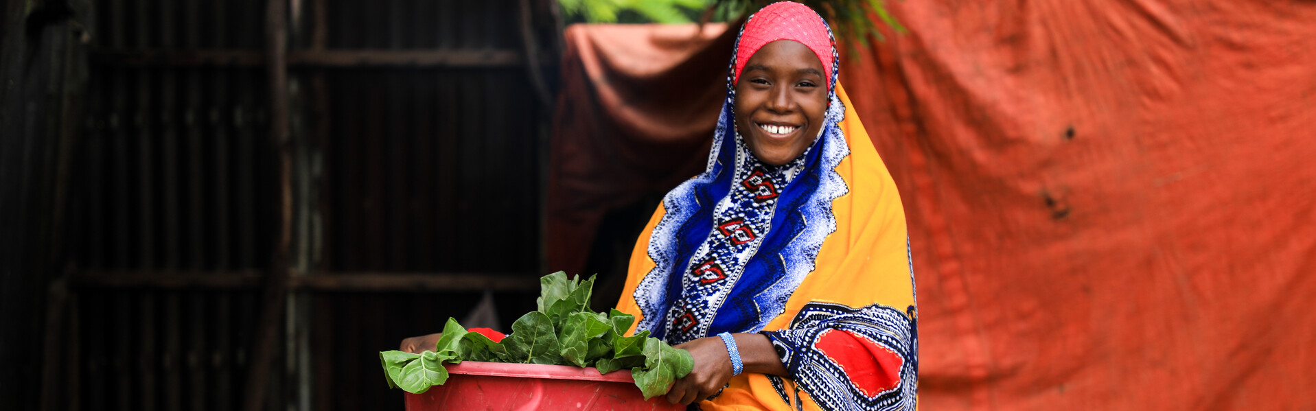 Eine Frau aus Somalia hält eine große Schüssel mit Salat in der Hand Eine Frau aus Somalia hält eine große Schüssel mit Salat in der Hand