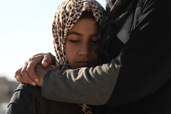 Eine Frau wird von einer anderen Person umarmt